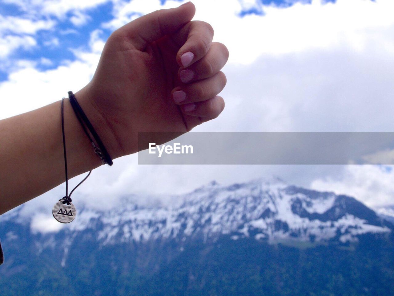 Cropped hand against mountain