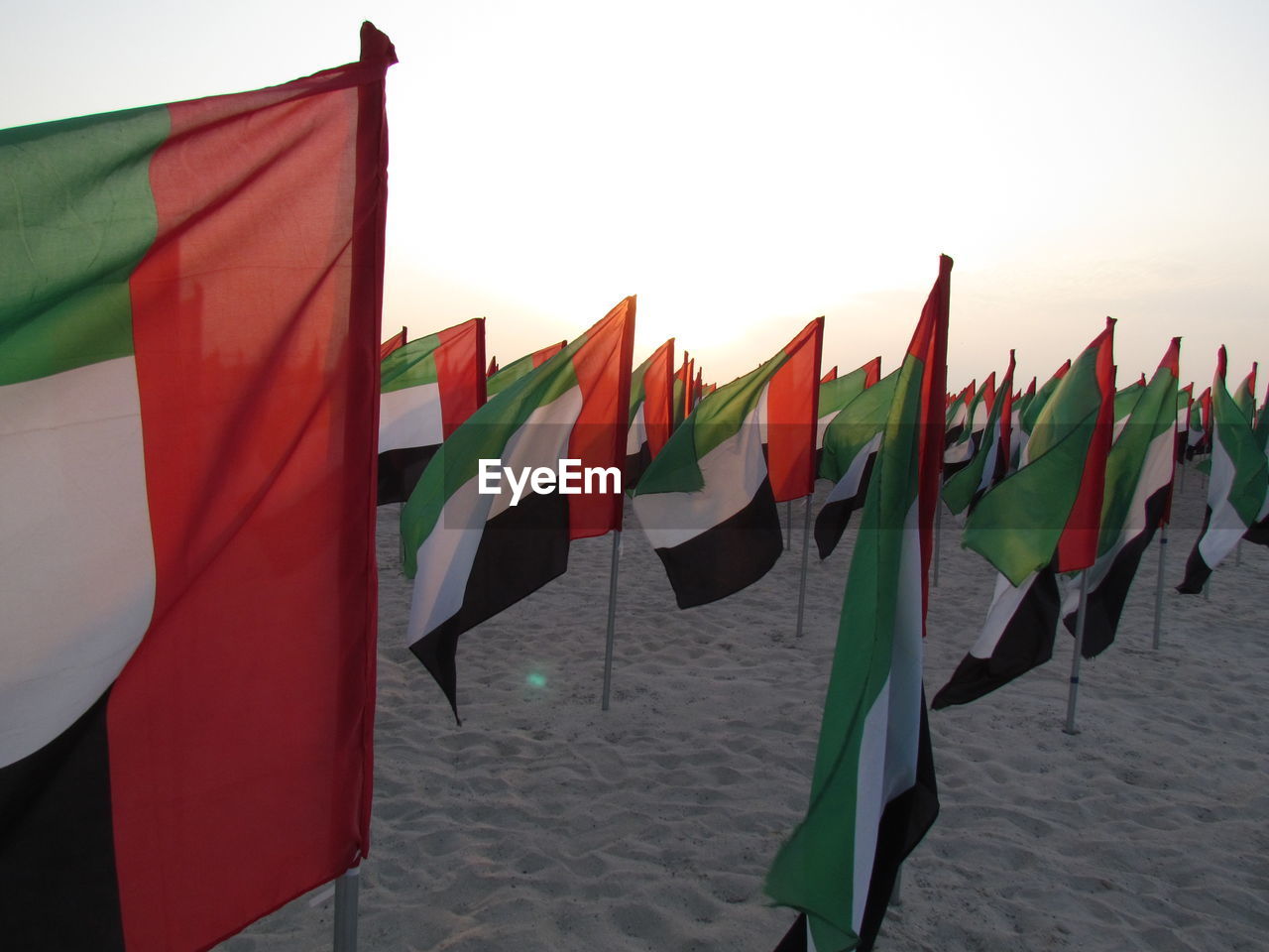 United arab emirates flags on sand against sky