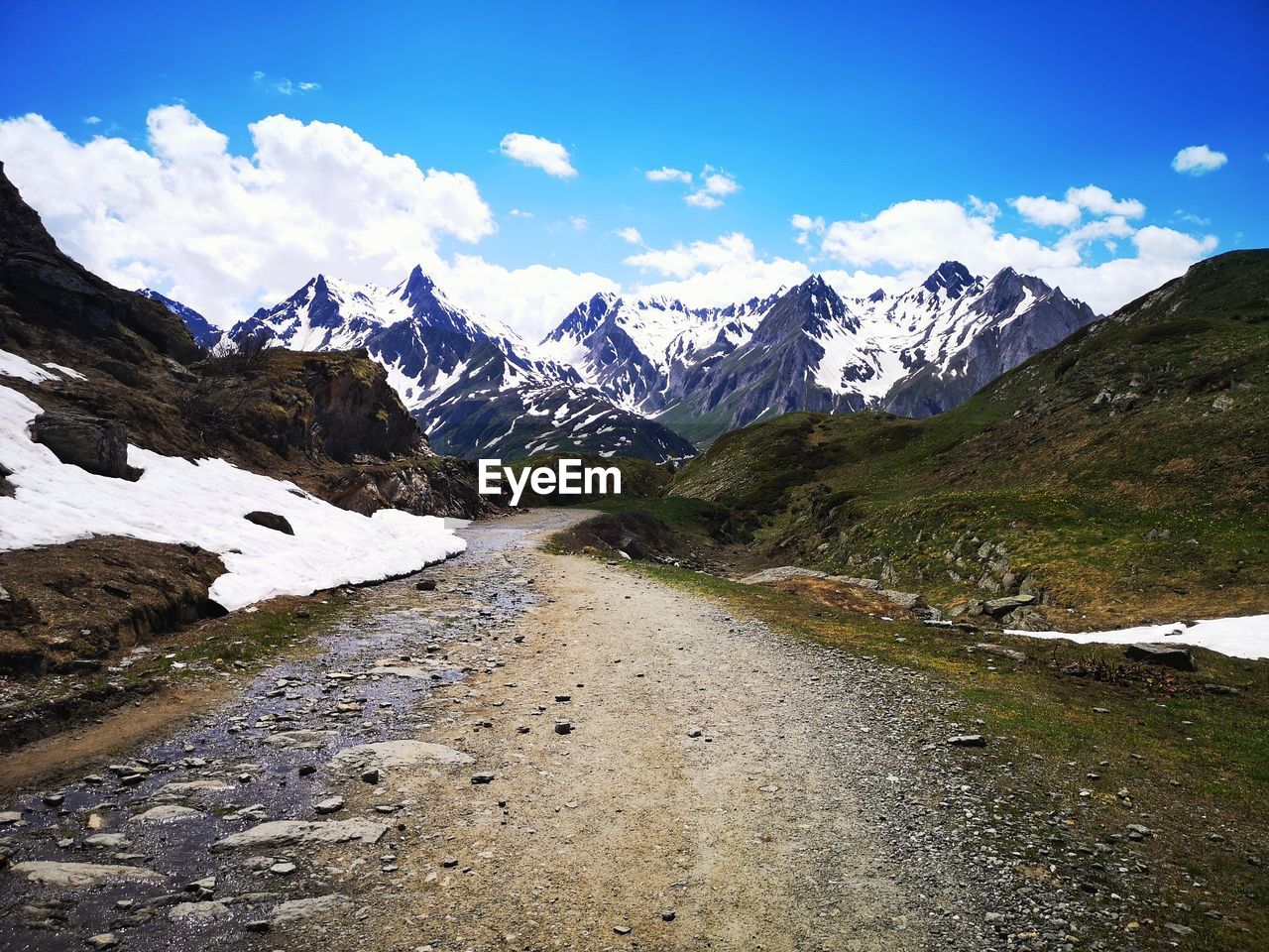 mountain, snow, environment, scenics - nature, landscape, sky, cold temperature, mountain range, beauty in nature, winter, mountain pass, nature, snowcapped mountain, cloud, walking, wilderness, travel, land, travel destinations, valley, road, hiking, mountain peak, ridge, tranquility, tranquil scene, blue, water, activity, ice, footpath, outdoors, backpacking, leisure activity, tourism, non-urban scene, adventure, plateau, day, glacier, transportation, grass, plant, idyllic, holiday, vacation, trip, lake, rock