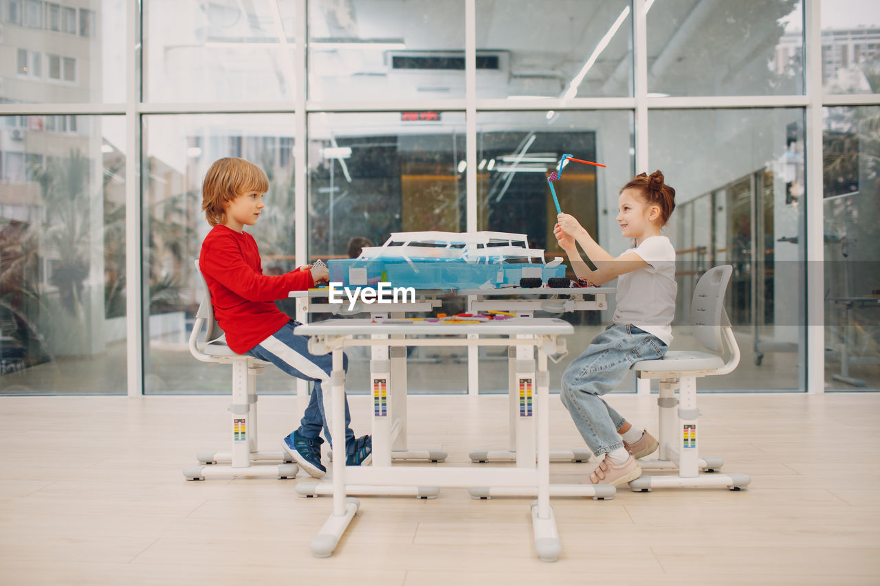 Siblings sitting on table