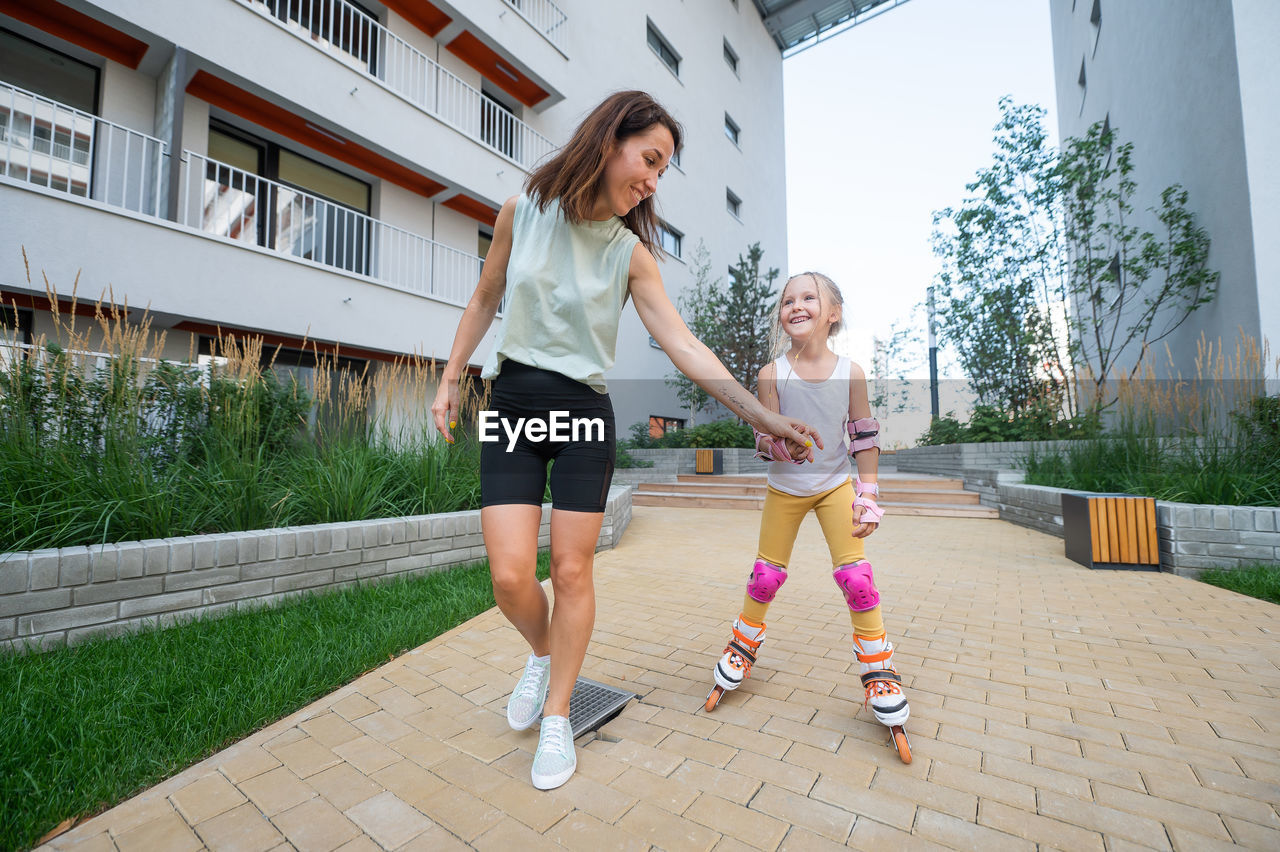 side view of young woman walking on footpath in city