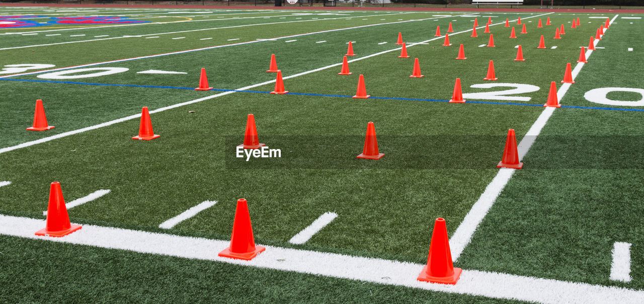 A green turf field set up with orange cones for athletes to do agility and speed training..