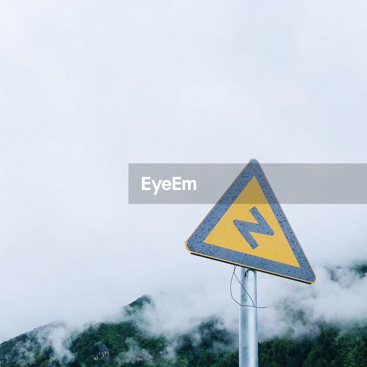Low angle view of road sign against cloudy sky