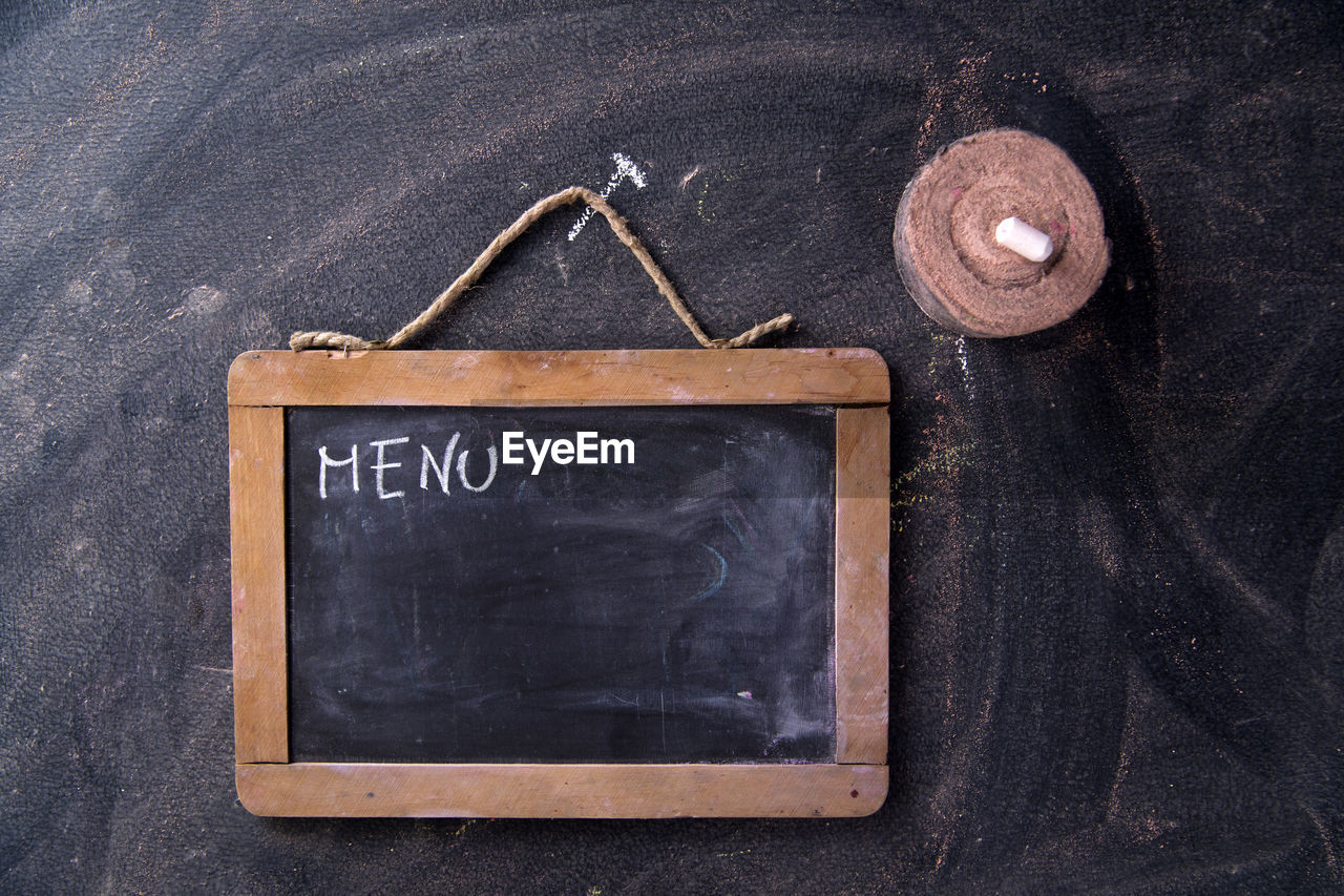 Directly above shot of menu text on chalkboard over table