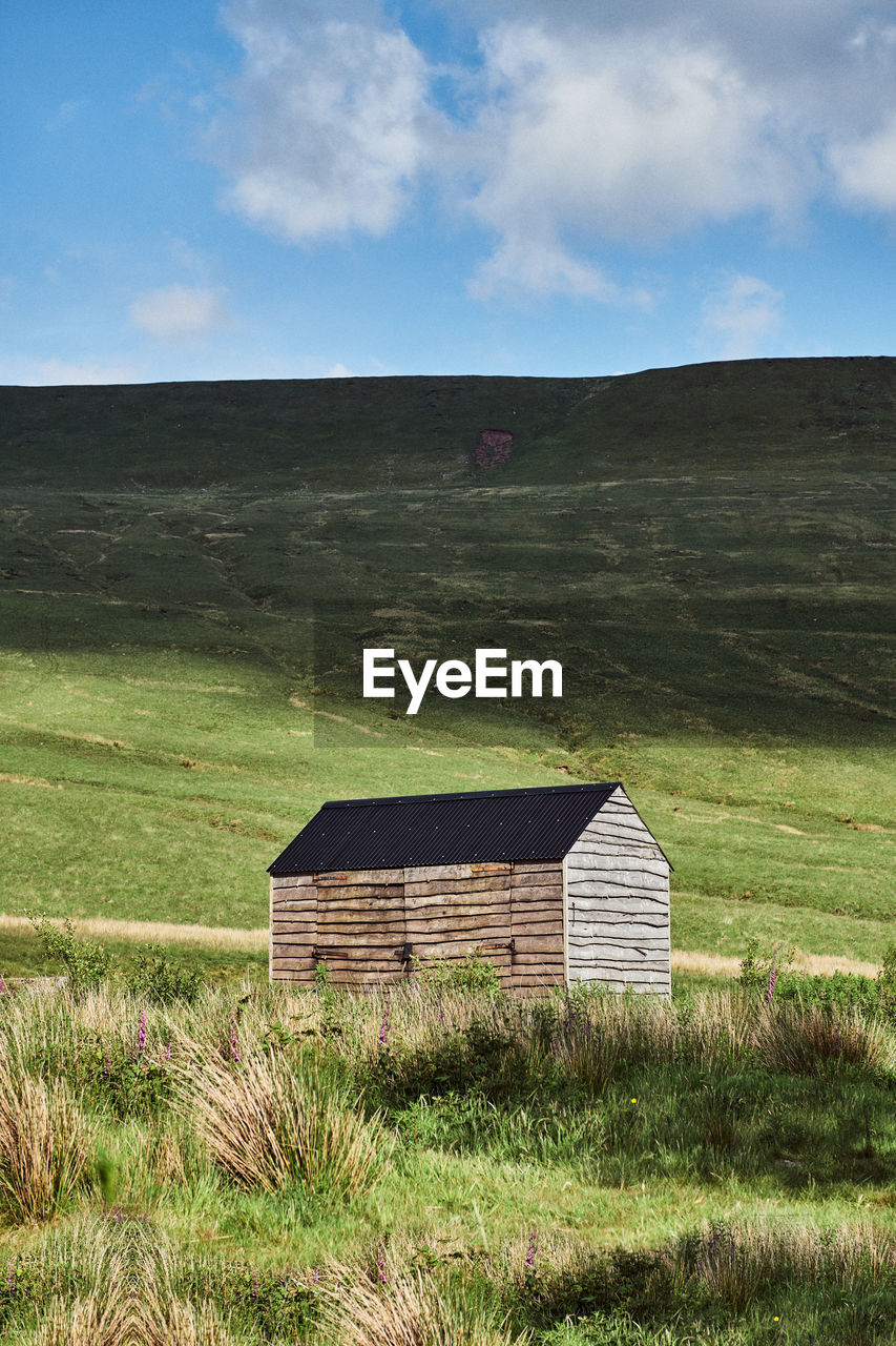 Barn on field against sky in wales