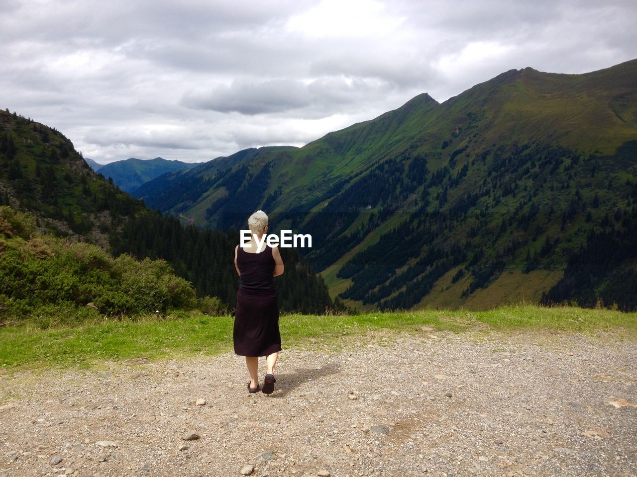 WOMAN STANDING ON MOUNTAIN LANDSCAPE