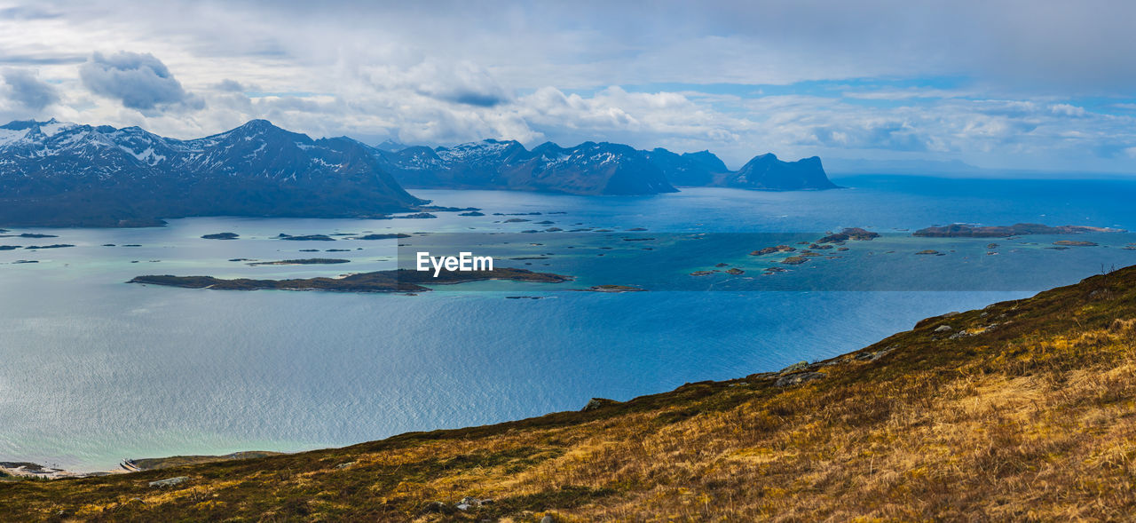 Scenic view of sea and mountains against sky