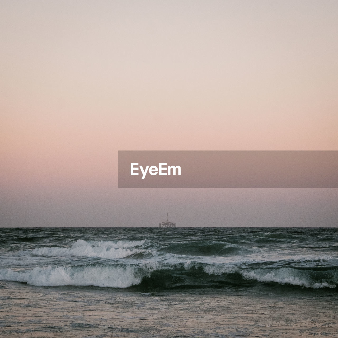 SCENIC VIEW OF BEACH AGAINST CLEAR SKY DURING SUNSET