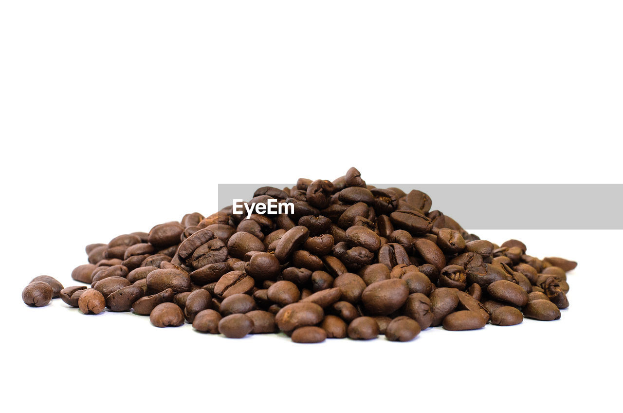 CLOSE-UP OF COFFEE BEANS ON WHITE BACKGROUND
