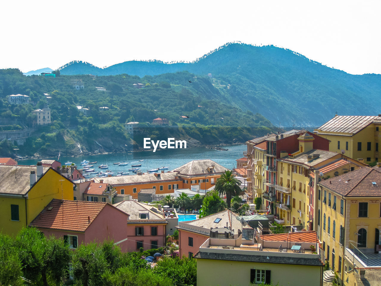 HIGH ANGLE VIEW OF TOWN BY SEA AGAINST SKY