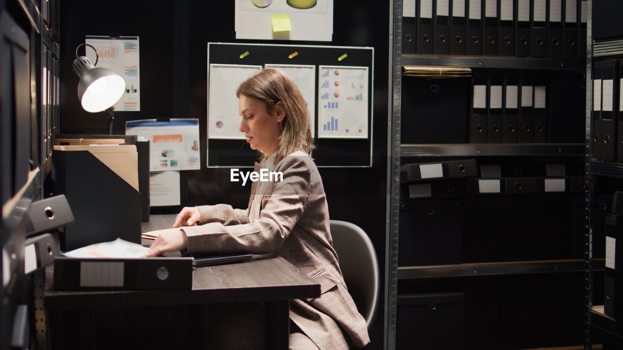 portrait of woman using laptop while sitting in office