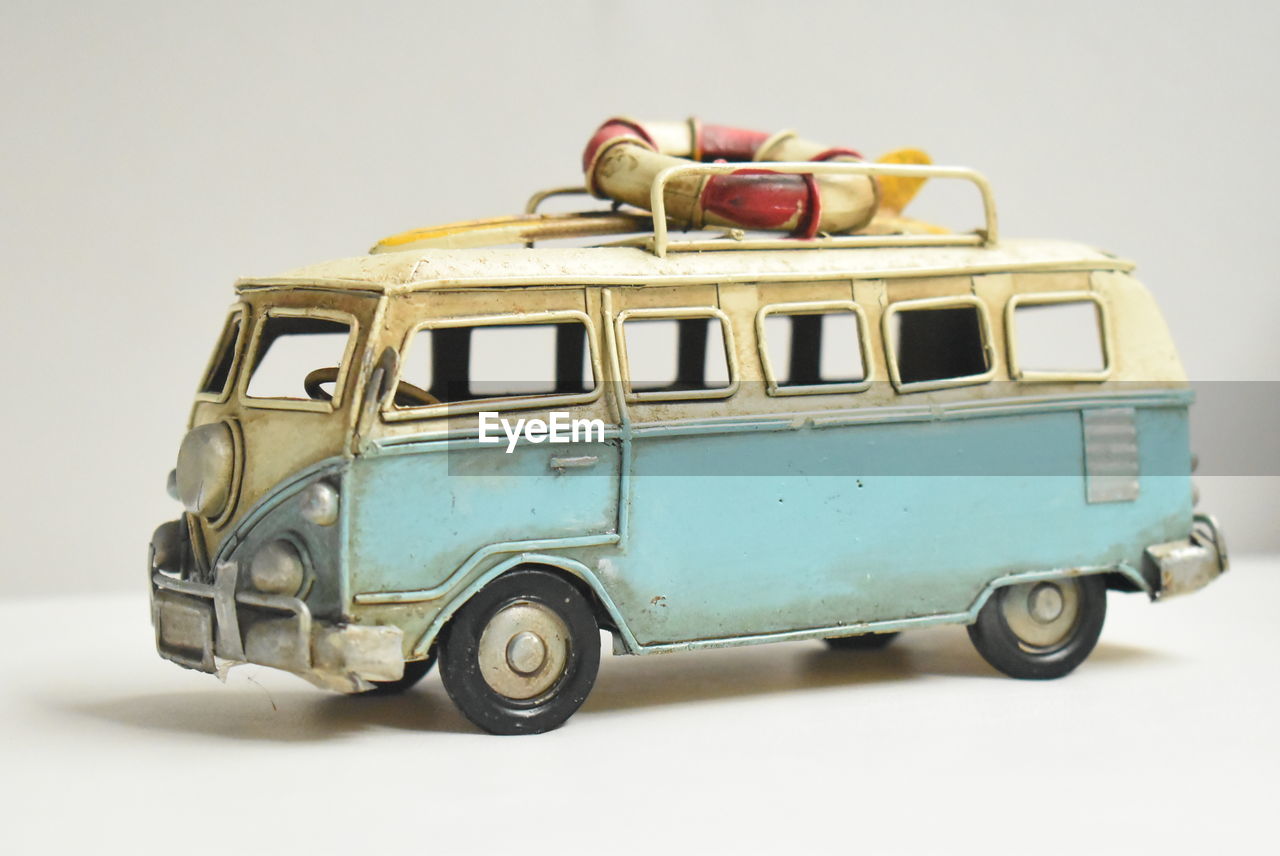 Close-up of old toy bus over white background