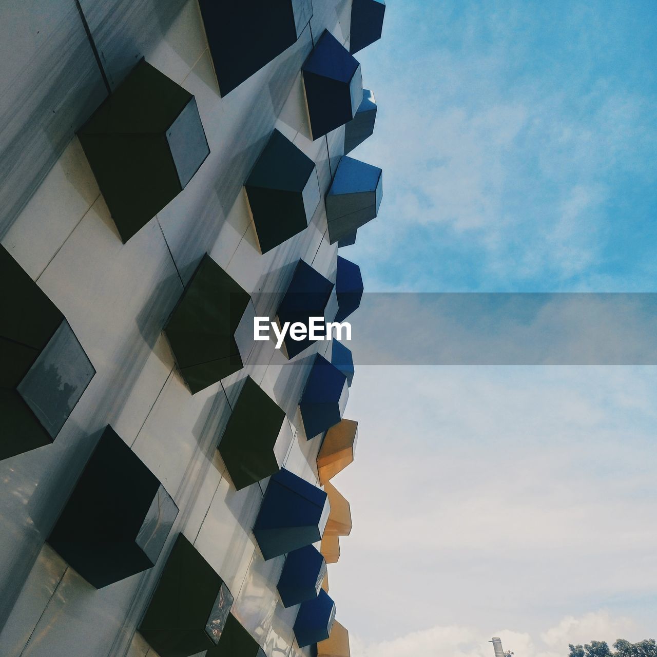 LOW ANGLE VIEW OF MODERN BUILDING AGAINST CLOUDY SKY