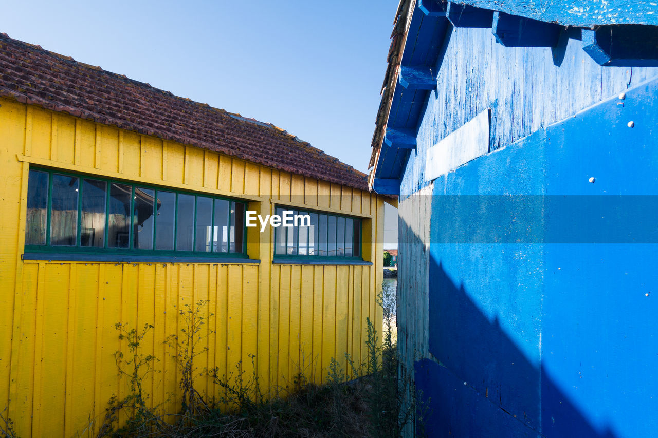 EXTERIOR OF YELLOW BUILDING AGAINST CLEAR BLUE SKY