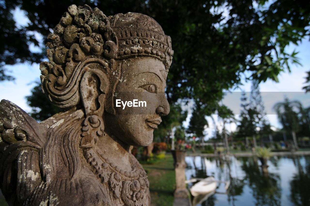 CLOSE-UP OF STATUE AGAINST BLURRED BACKGROUND