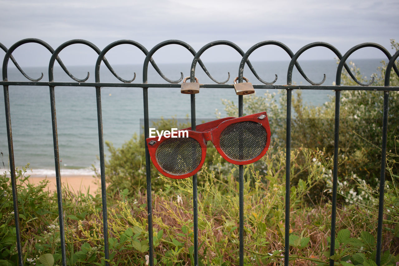 RED METAL FENCE AGAINST SEA