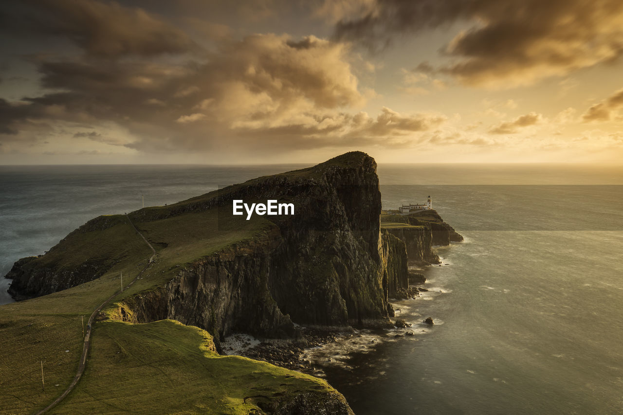 Scenic view of sea against cloudy sky during sunset