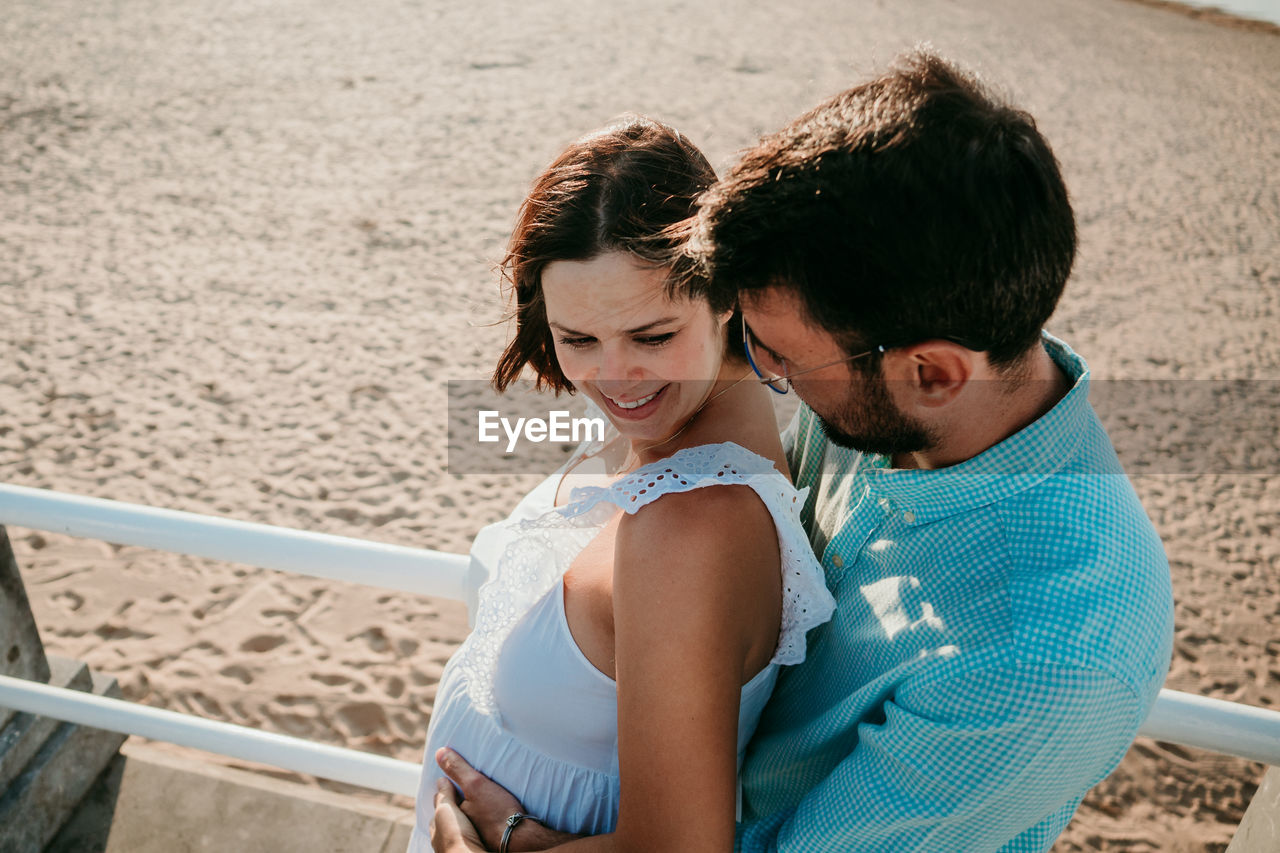 Couple embracing while standing on beach