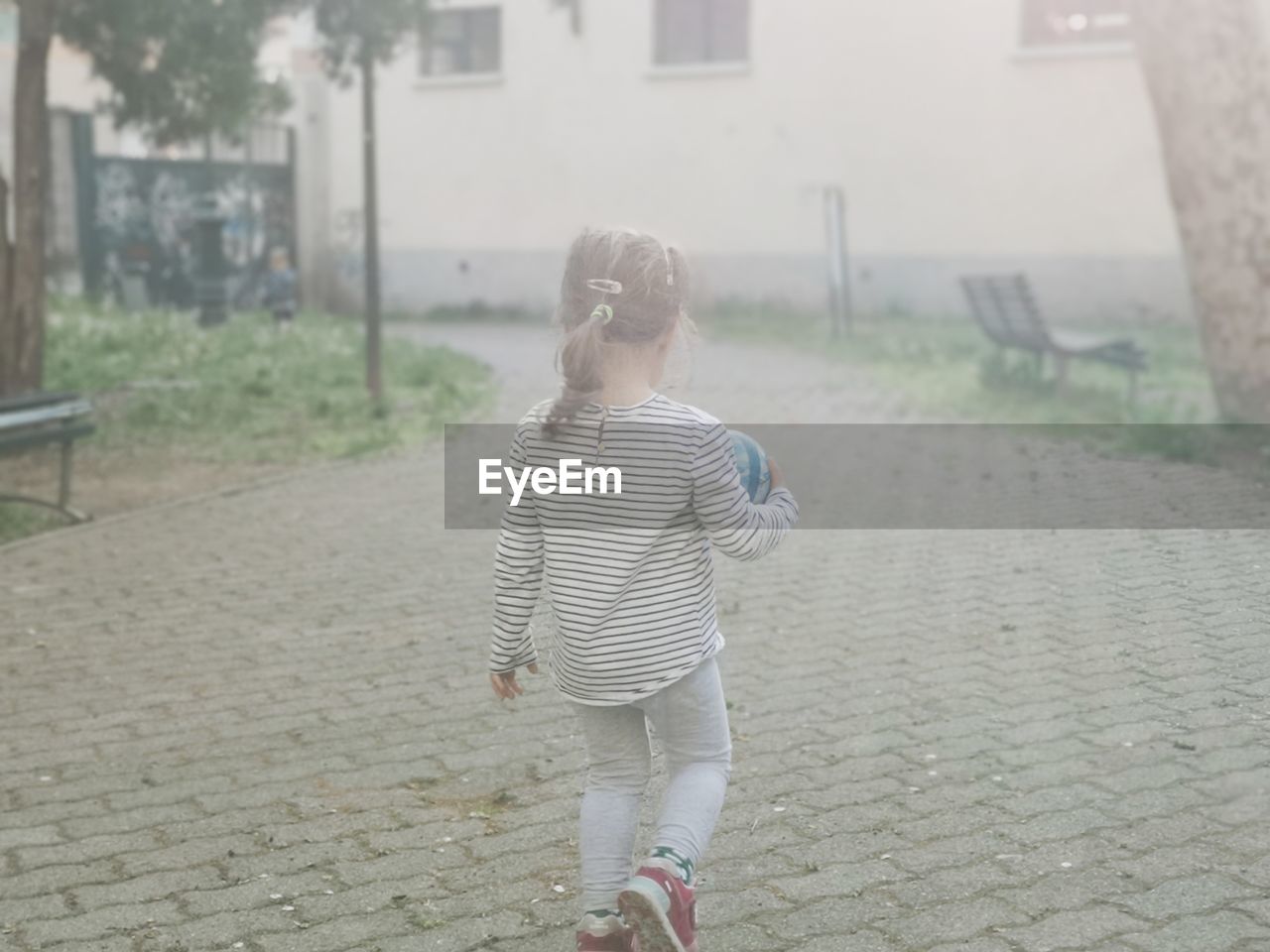 REAR VIEW OF WOMAN WITH UMBRELLA WALKING ON STREET