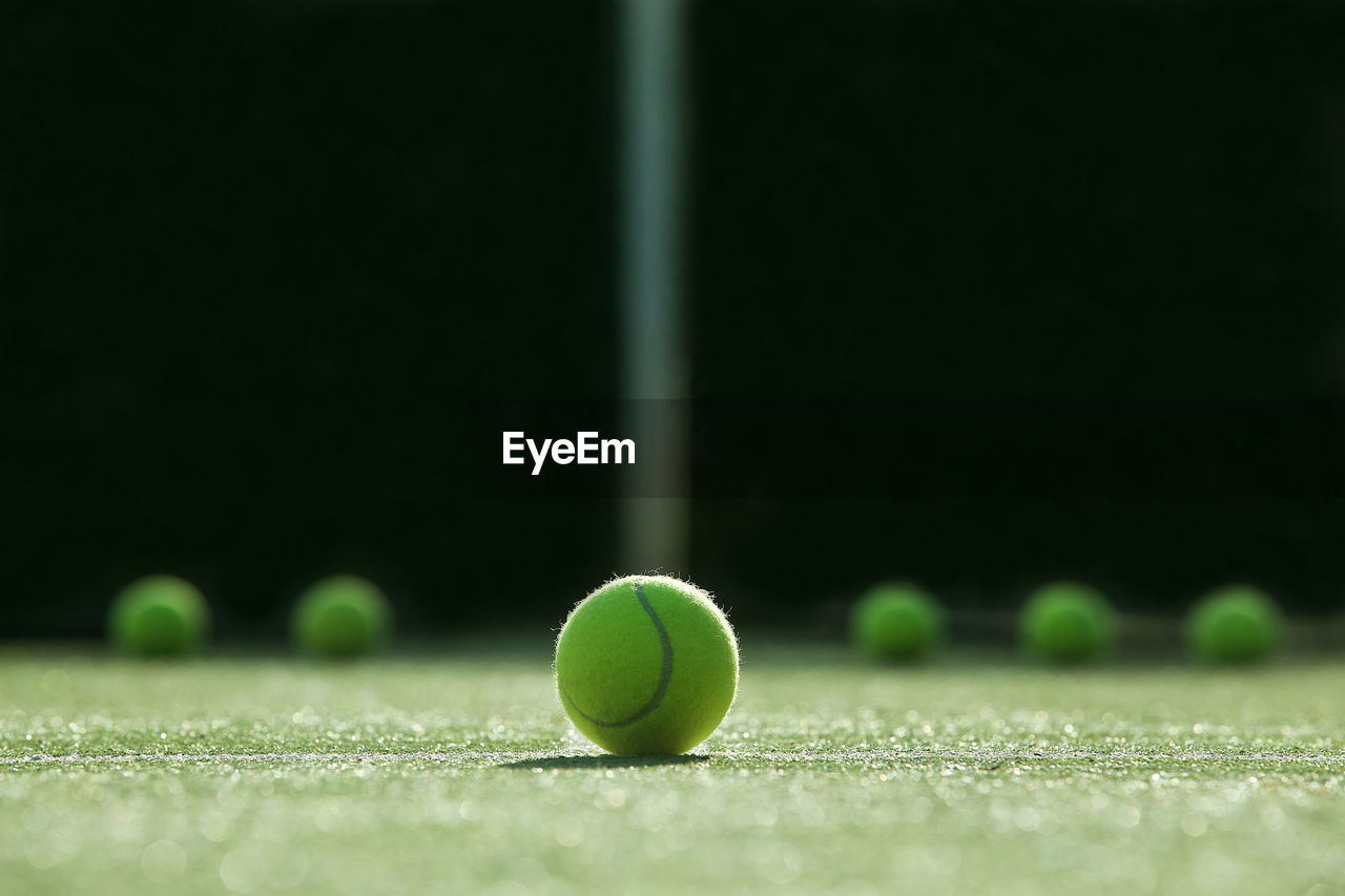 Close-up of tennis balls on field in court