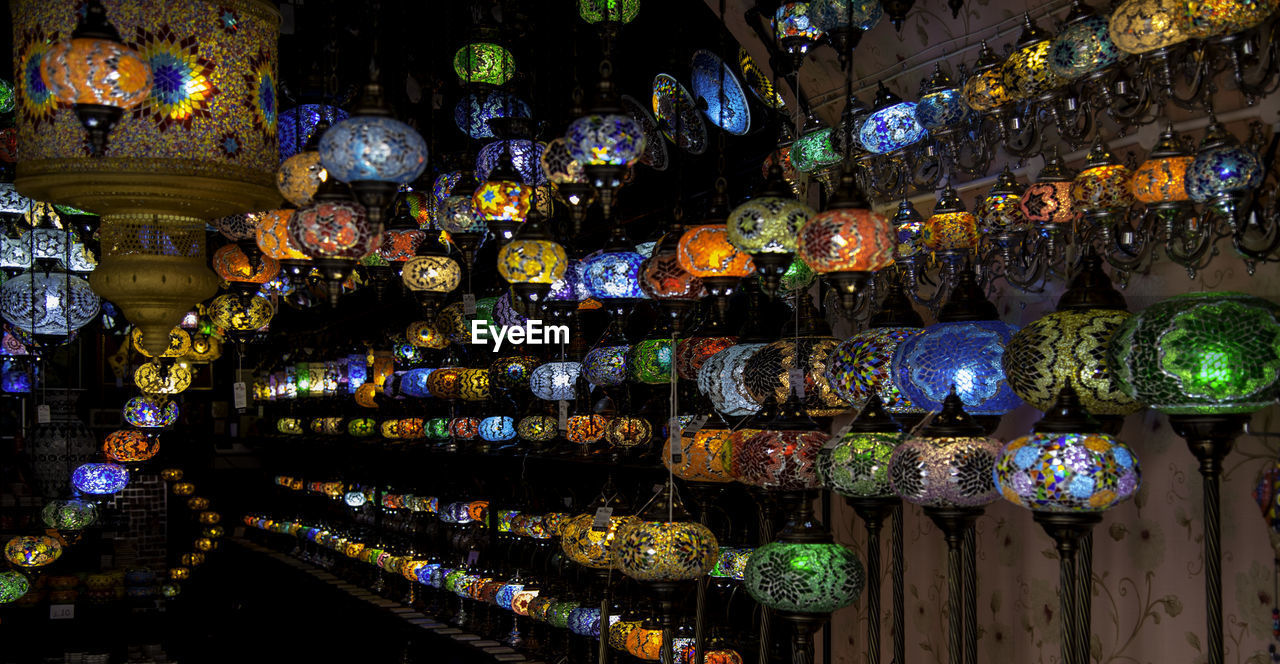 Multi colored lanterns hanging in shelf at market stall