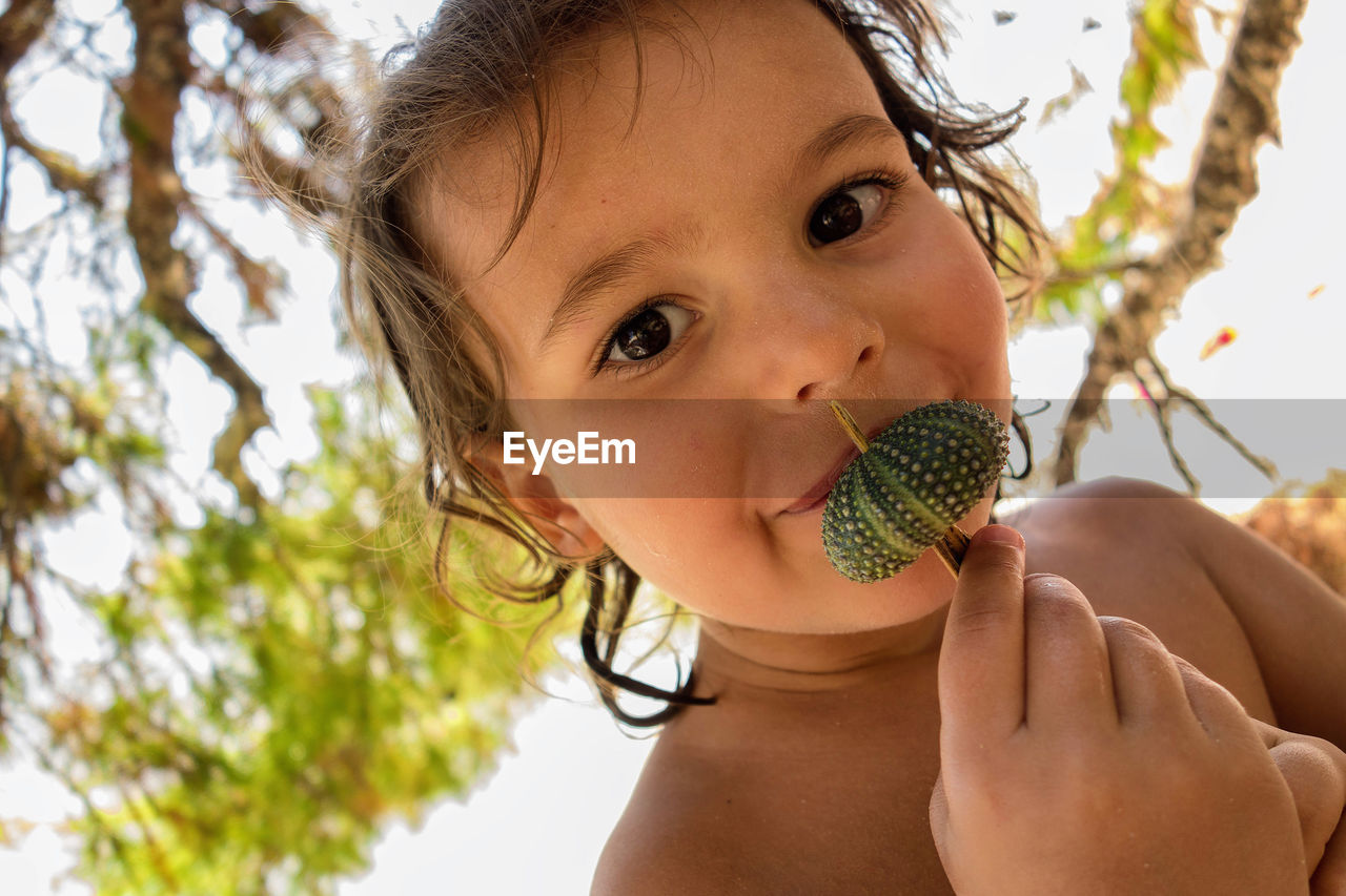 Close-up portrait of girl holding fruit