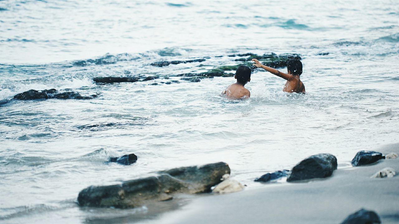 Boys swimming in sea