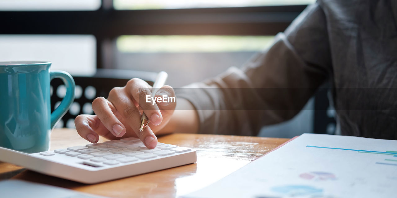 MIDSECTION OF MAN USING LAPTOP