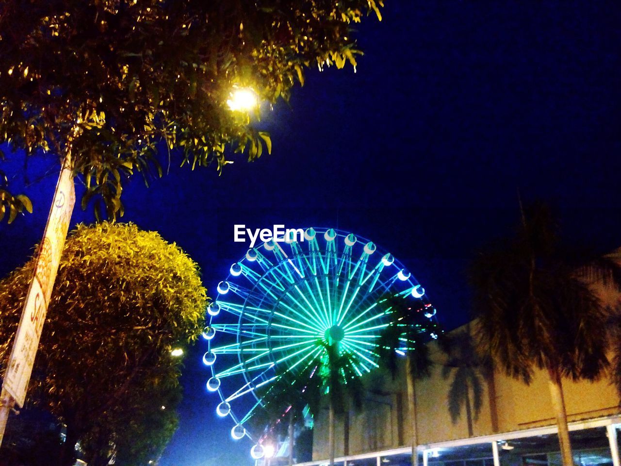 LOW ANGLE VIEW OF ILLUMINATED LIGHTS AT NIGHT