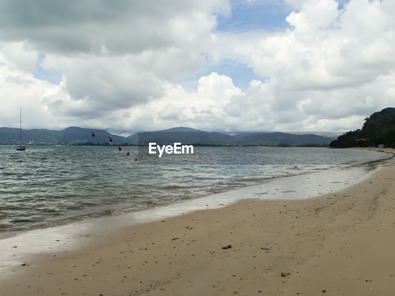 SCENIC VIEW OF BEACH BY MOUNTAINS AGAINST SKY