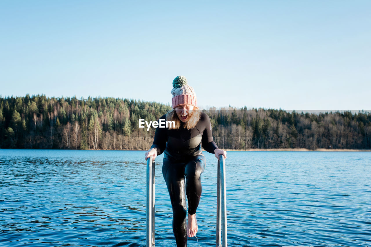 Woman screaming from swimming in the cold water in the sea in winter