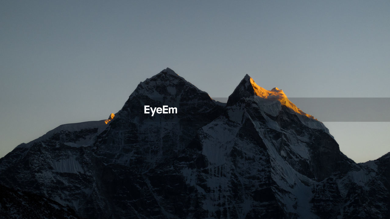 Low angle view of snowcapped mountain against sky during sunset