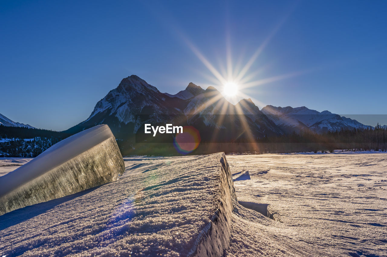 Scenic view of snowcapped mountains against blue sky