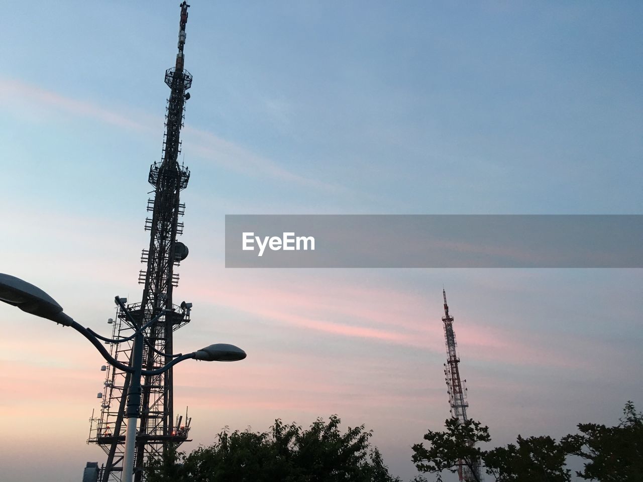 Low angle view of communications towers during sunset