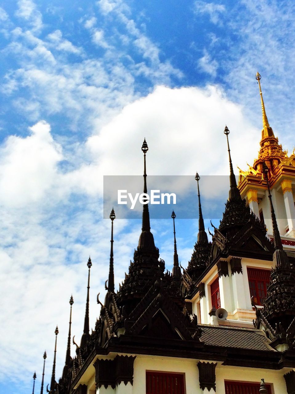 Low angle view of wat ratchanatdaram against cloudy sky