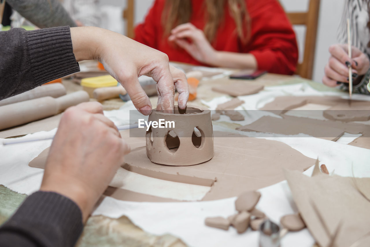 Women's hands knead clay, drawing elements of the product. production of ceramic products. 