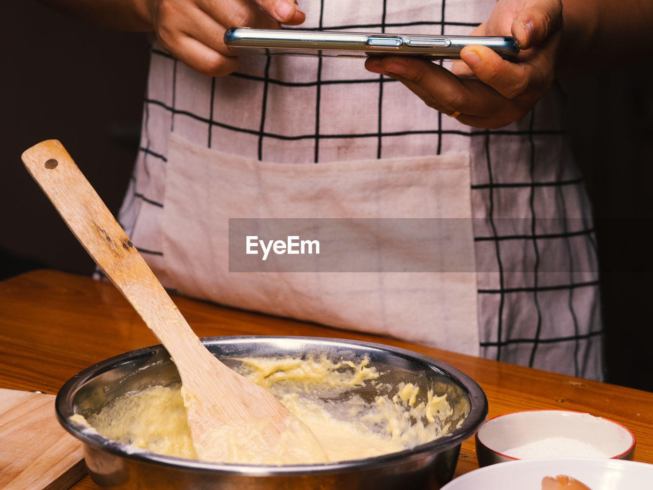 MIDSECTION OF MAN HAVING FOOD IN KITCHEN