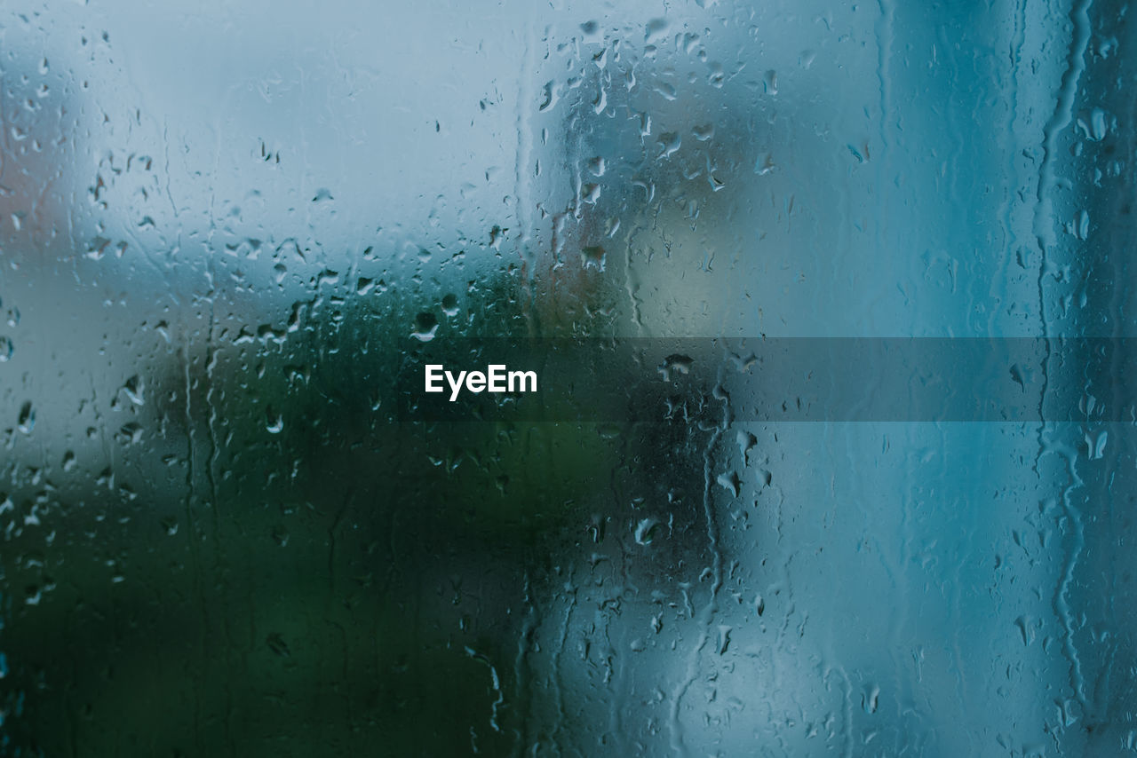 Full frame shot of wet glass window in rainy season