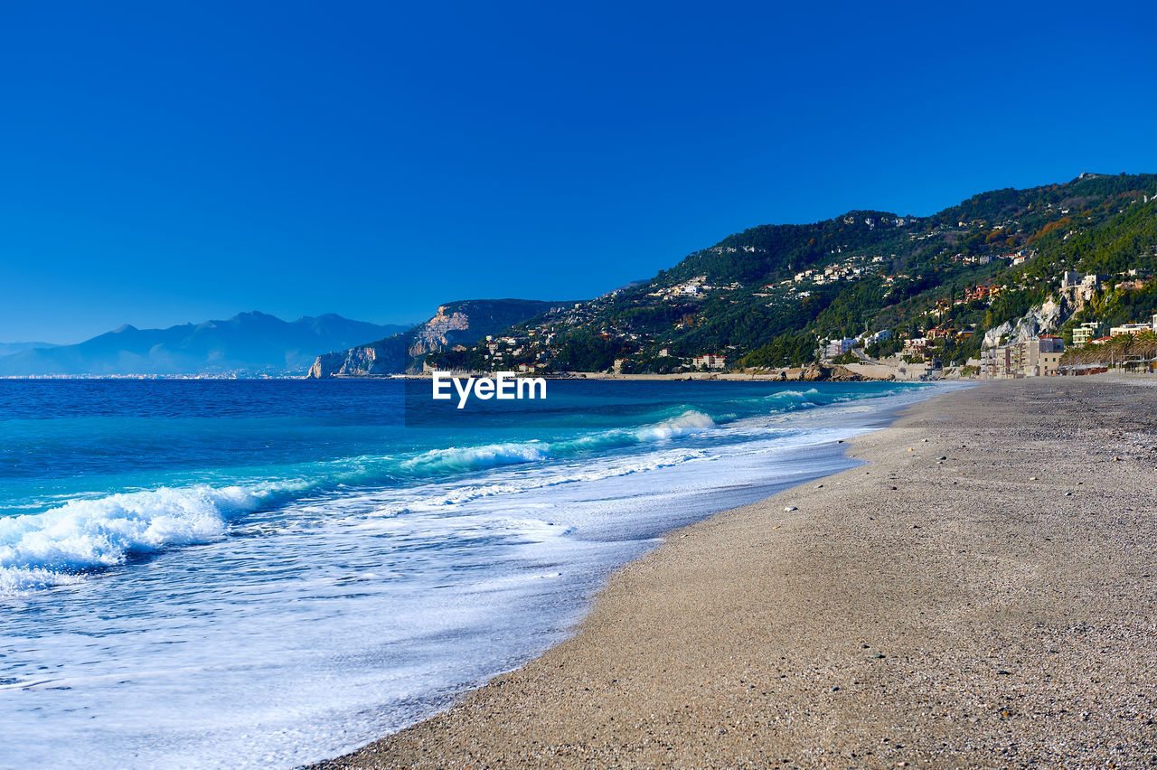 Scenic view of beach against blue sky