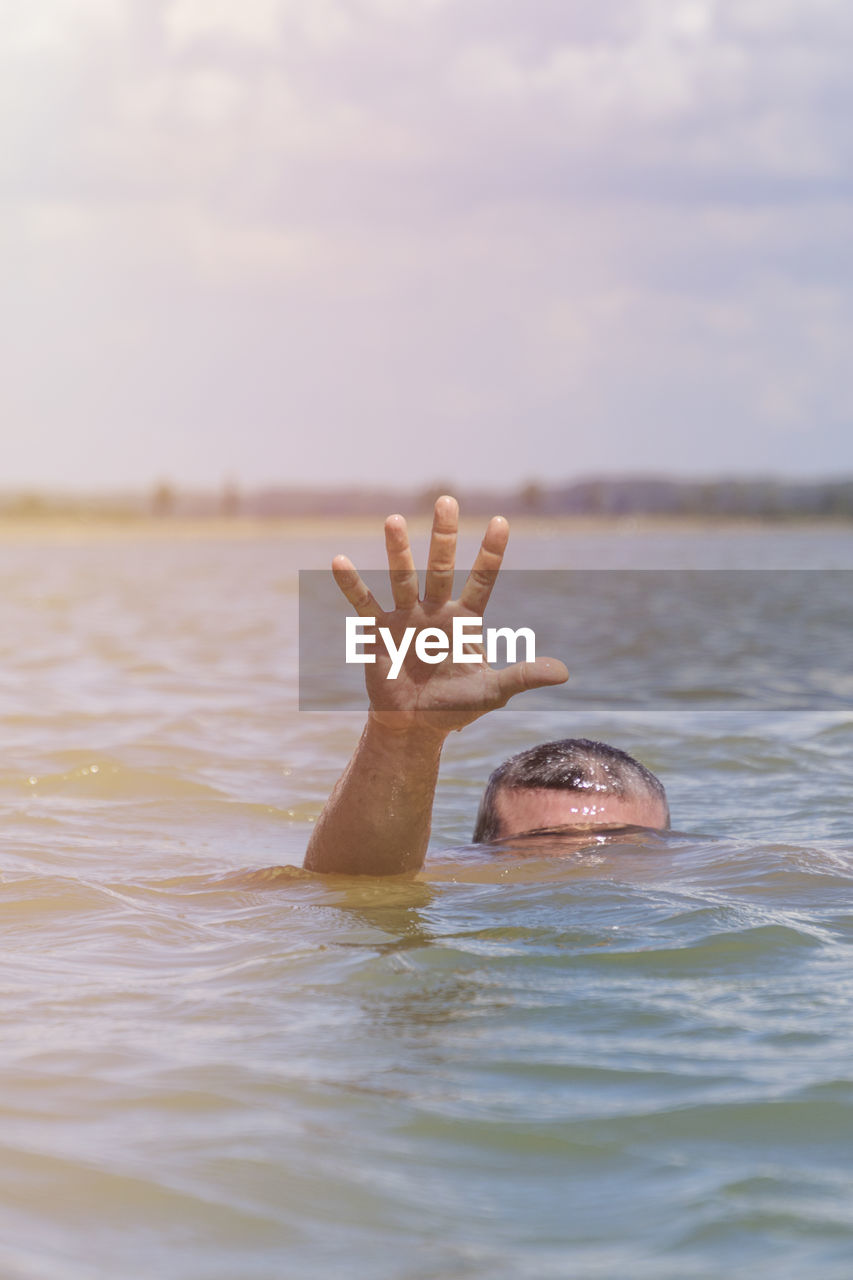 Cropped image of person drowning in sea