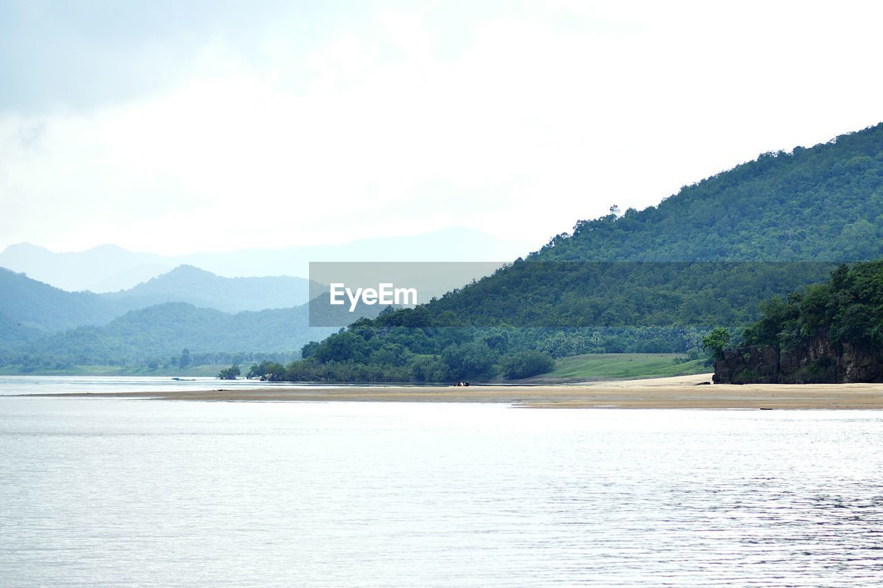 Calm countryside lake against mountain range