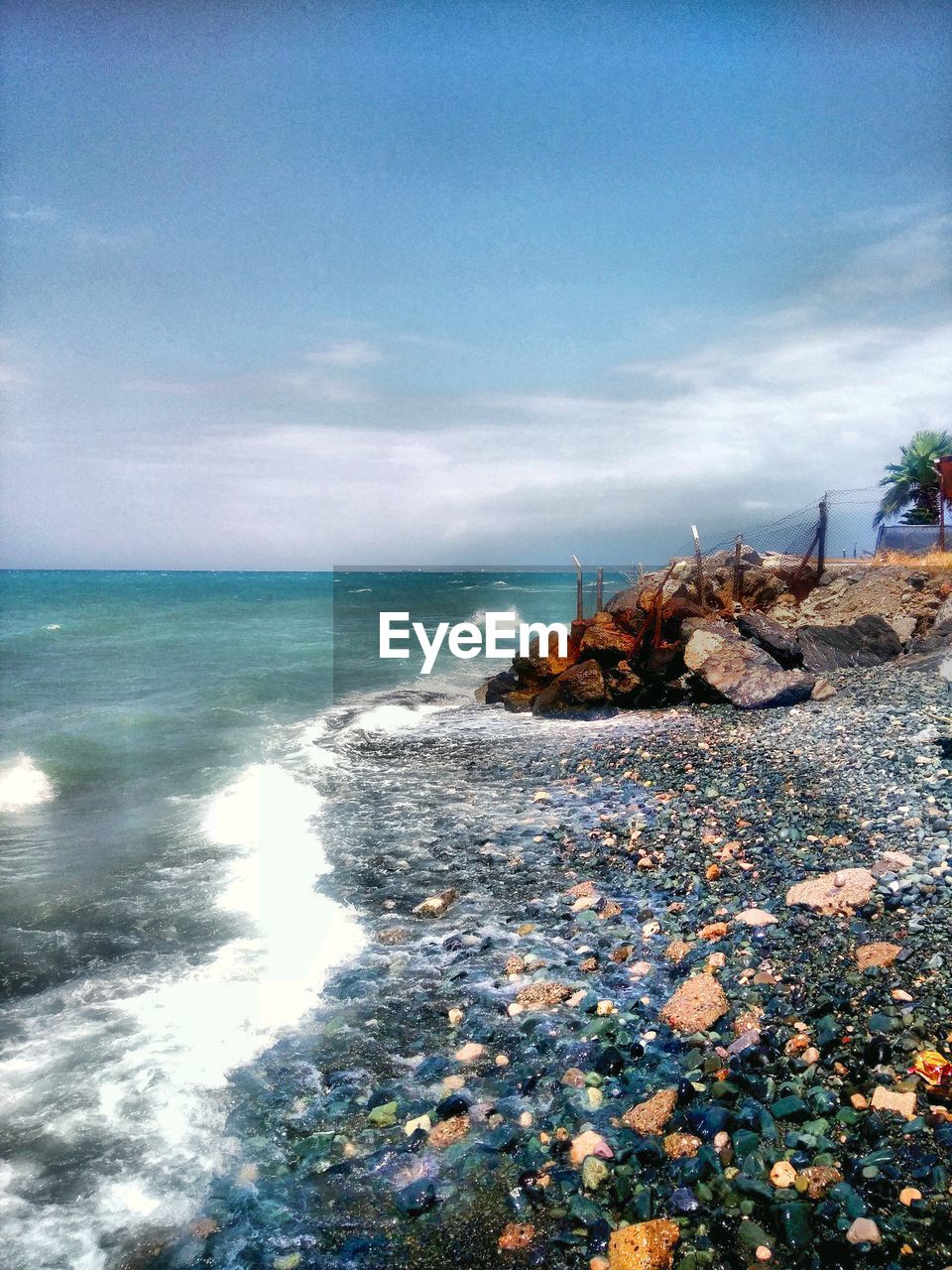 SCENIC VIEW OF ROCKS ON BEACH AGAINST SKY