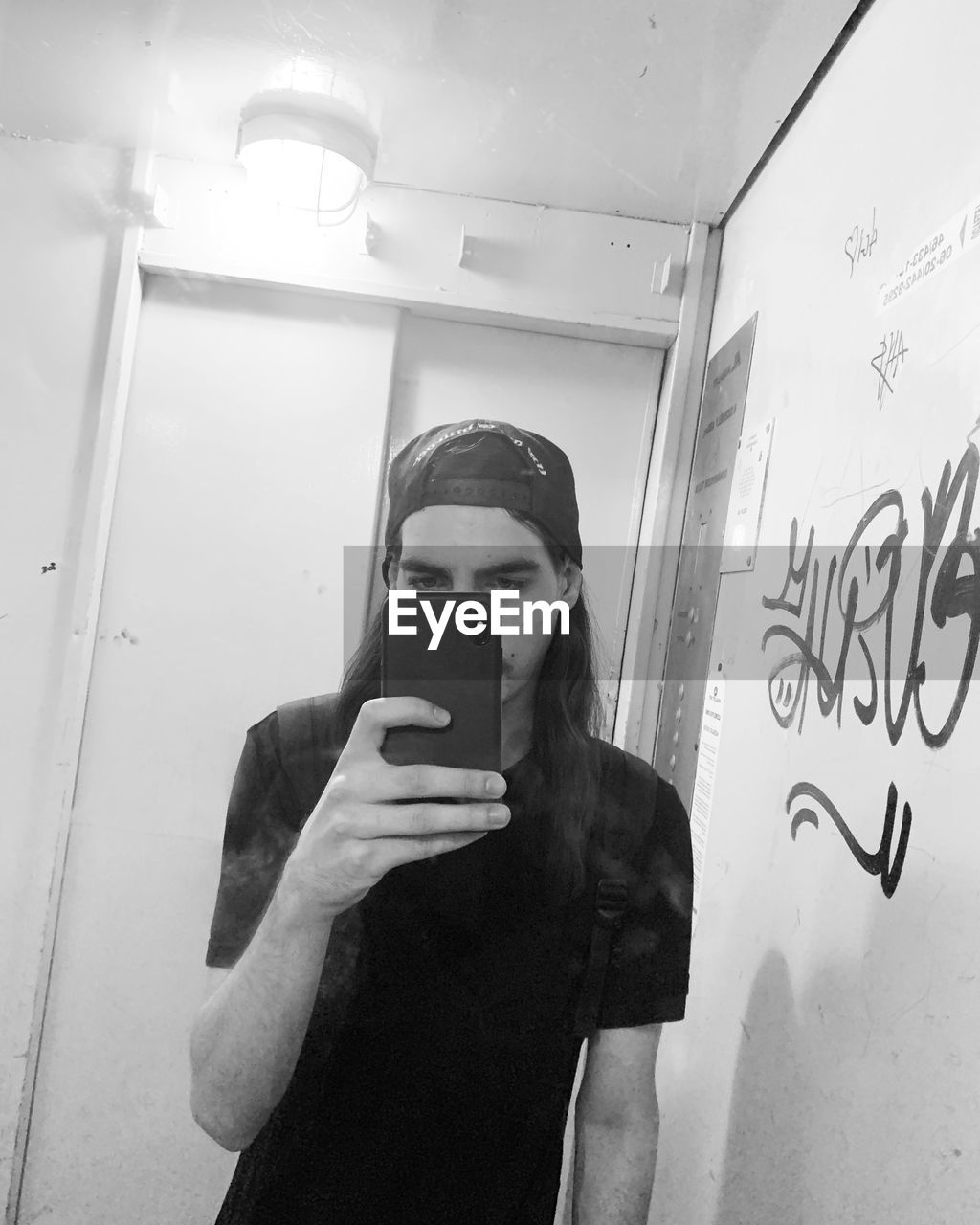 black, white, one person, black and white, communication, technology, adult, wireless technology, monochrome, activity, smartphone, mobile phone, monochrome photography, indoors, portable information device, lifestyles, waist up, holding, young adult, photographing, selfie, telephone, women, standing, graffiti