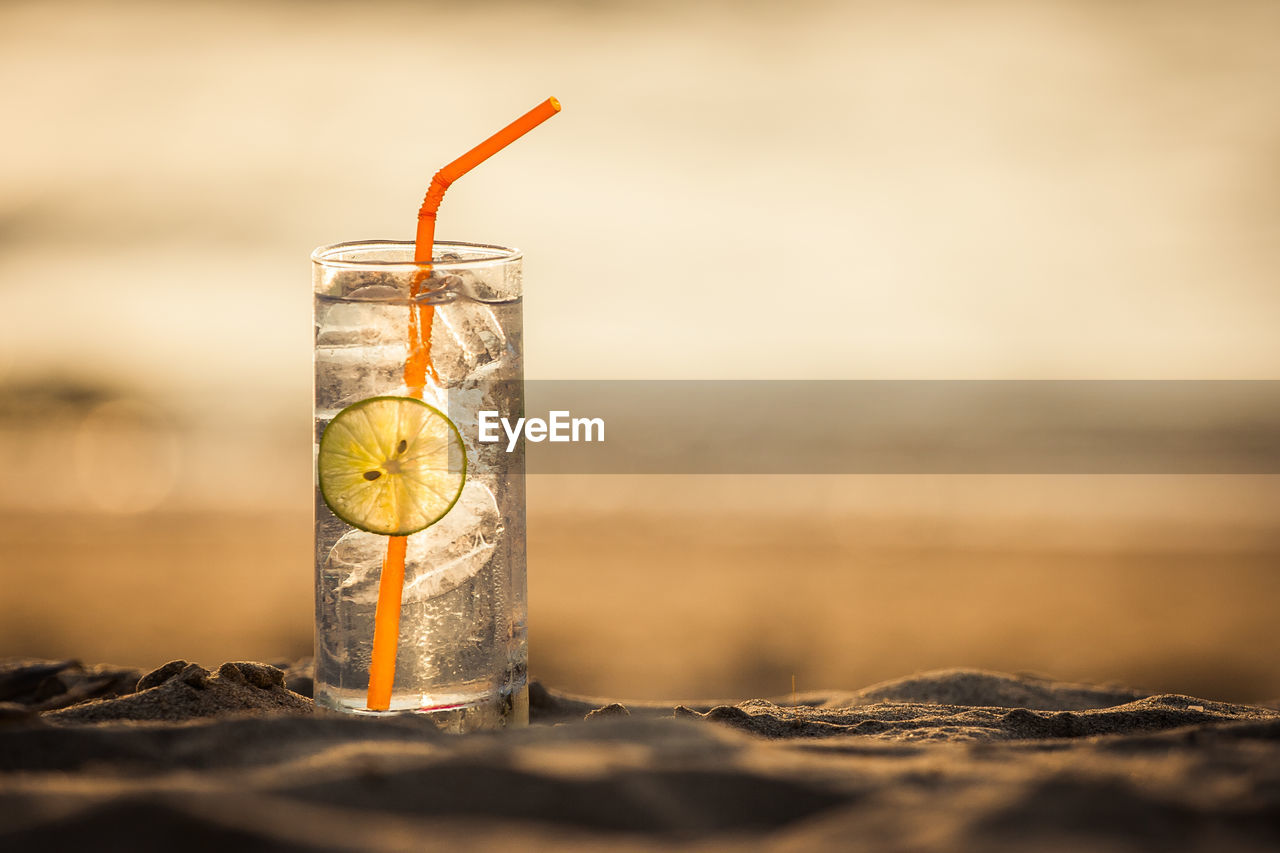 CLOSE-UP OF DRINK ON GLASS TABLE