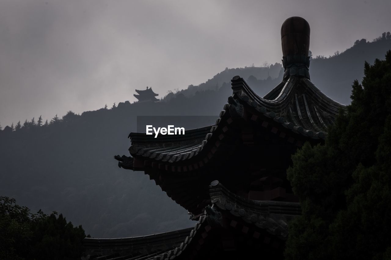 Low angle view of temple and building against sky