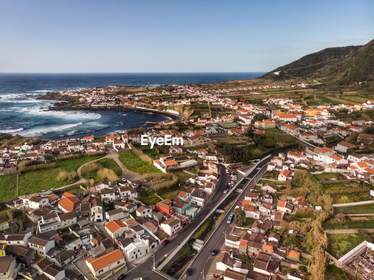 High angle view of buildings and sea against clear sky