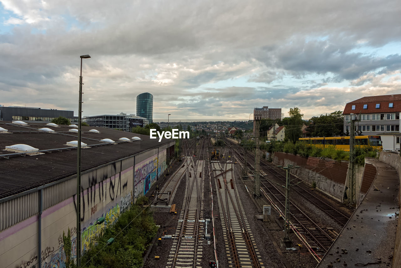 HIGH ANGLE VIEW OF TRAIN IN CITY AGAINST SKY