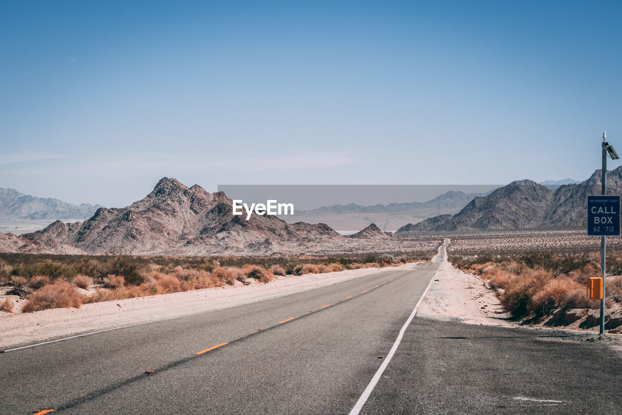 Road by mountain against clear sky