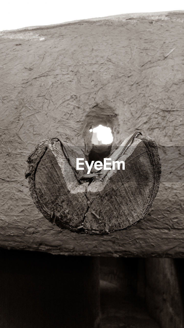 CLOSE-UP OF ILLUMINATED LIGHT BULB ON STONE WALL