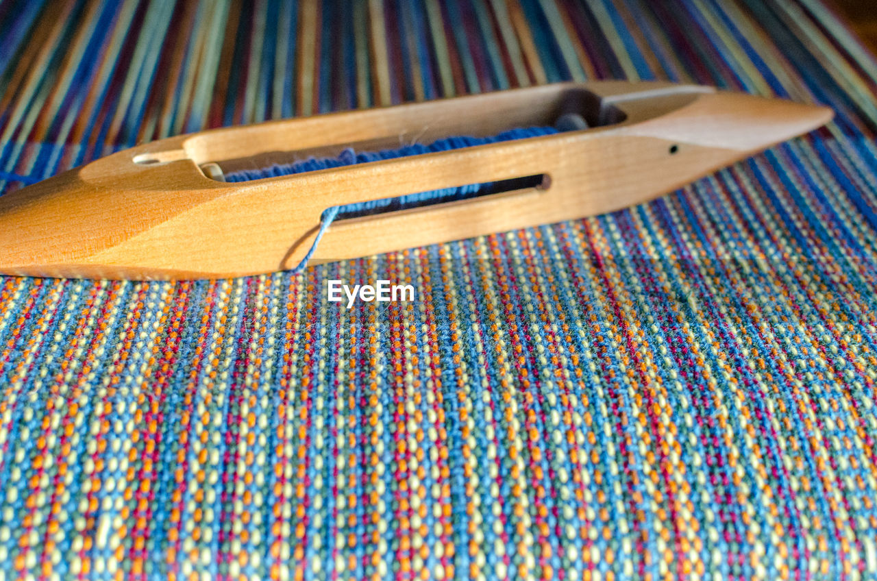 Close-up of wooden equipment on colorful thread